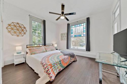 Un dormitorio con una cama y un televisor de pantalla plana. en Historic home with heated Mini Pool walking distance to downtown San Antonio!, en San Antonio