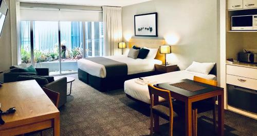 a hotel room with two beds and a table at Quest Brighton on the Bay in Melbourne