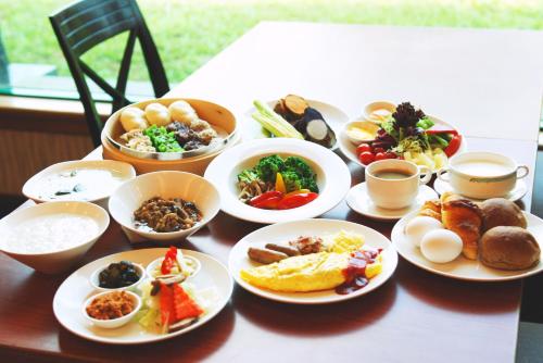 een tafel met borden en kommen eten bij Uni-Resort Mawutu in Guanxi