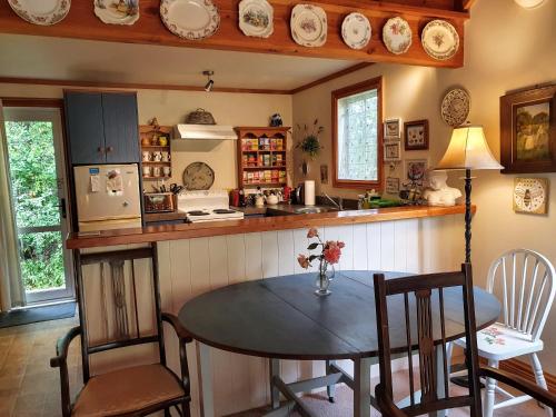 a kitchen with a table and chairs and a counter at Bumblebee Cottage in Greytown