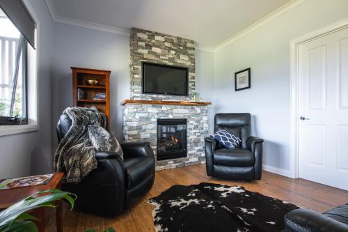 a living room with two chairs and a fireplace at Manna Hill Farm in West Kentish