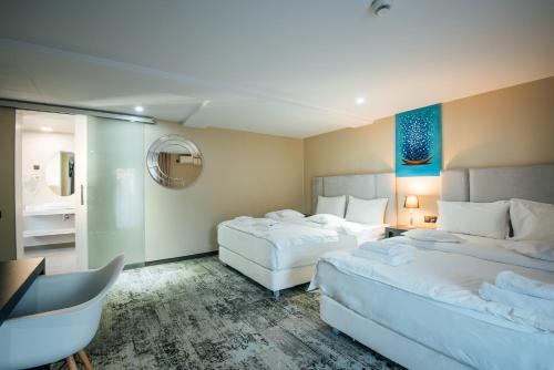 ソバタにあるVila Fabescaのベッド2台とデスクが備わるホテルルームです。