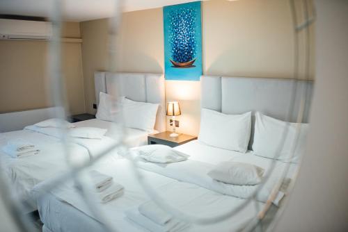 two beds in a room with white sheets and pillows at Vila Fabesca in Sovata