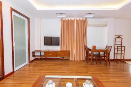 a living room with a table and a desk at Lotus Hotel Hai Duong in Hải Dương
