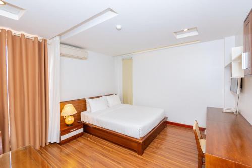 a bedroom with a bed and a table and a television at Lotus Hotel Hai Duong in Hải Dương