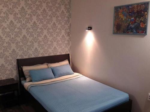 a small bedroom with a bed with blue sheets at Morskaya Hotel in Yeysk