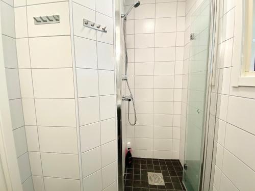 a bathroom with a shower with white tiles at Sörbygården Bed & Breakfast in Brunflo