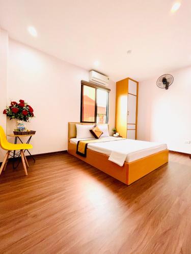 a bedroom with a large bed and a yellow chair at A&EM VILLA in Hanoi