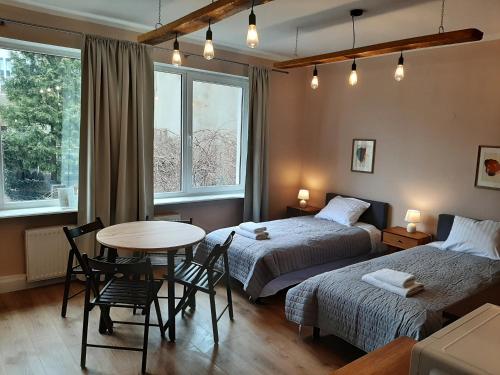 sypialnia z dwoma łóżkami, stołem i krzesłami w obiekcie Drzewna Apartamenty - Kupiecka 5 w Zielonej Górze