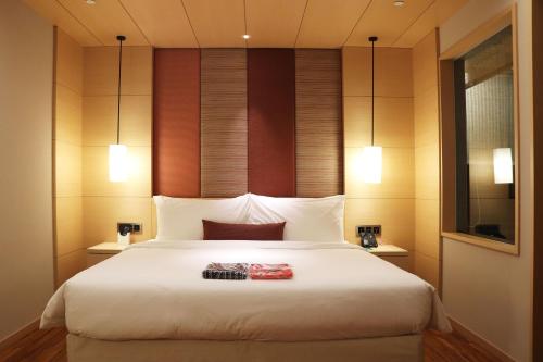 a bedroom with a large white bed with two lights at Asia Pacific Hotel Beitou in Taipei