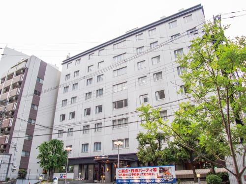 a white building with a sign in front of it at Hotel Shin Osaka in Osaka