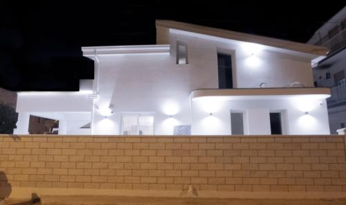 a white house with lights on top of a building at The Simo's House Camere a Marzamemi in Marzamemi