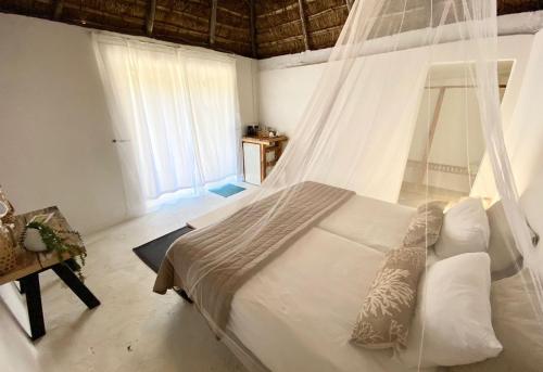 a bedroom with a bed with a mosquito net at Sunset Bed and Breakfast in Coffee Bay
