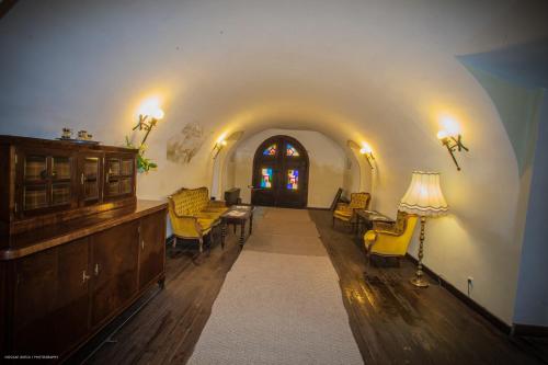 a living room with yellow chairs and a table at Hotel Sighişoara in Sighişoara