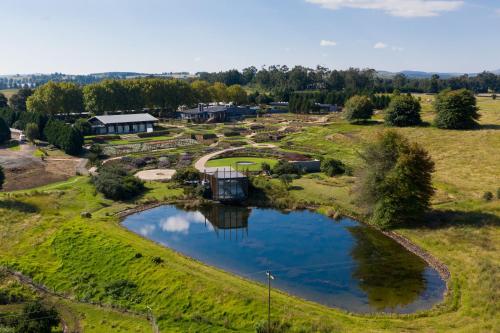 an aerial view of a farm with a pond at Brahman Hills - Gardens, Hotel & Cottages in Nottingham Road