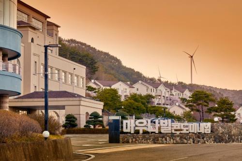 a town with a windmill in the background with buildings at Gyeongju Mauna Ocean Resort in Gyeongju