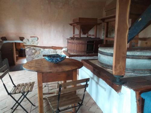 Habitación con mesa, sillas y fogones. en Molino Del Río en Torre la Cárcel