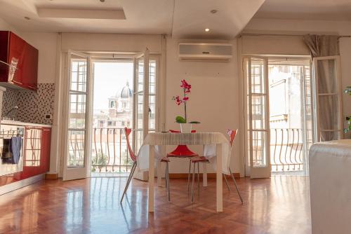 a kitchen with a table with a vase of flowers on it at Appartamento Gaudi in Lido di Ostia