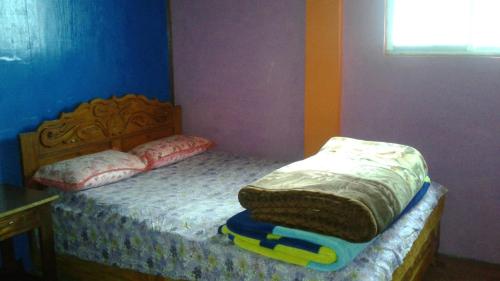 a small bedroom with a bed with a blanket on it at Vamoose Heema Homestay in Ghum
