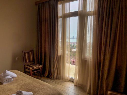 a hotel room with a large window and a chair at House for rest in Batumi