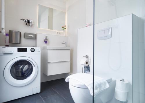 een badkamer met een wasmachine en een toilet bij Hamburg Nord Apartments in Hamburg