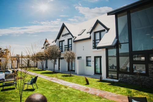 Casa blanca con ventanas negras y patio en Giardino Boutique Hotel, en Swakopmund