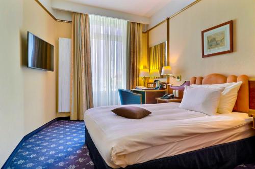 a hotel room with a large bed and a large window at Hotel Mirabeau, BW Signature Collection, Lausanne in Lausanne