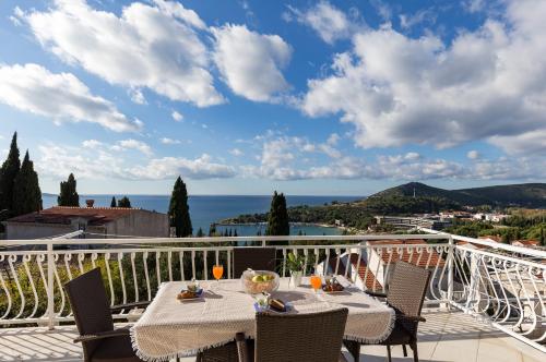 a table on a balcony with a view of the ocean at Apartments Villa Enzian in Mlini