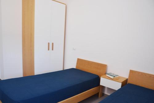 a small bedroom with two beds and a door at Splendida Villa NATURE-APPARTAMENTO MELOGRANO a SCOPELLO-ZINGARO vista sul mare in Scopello