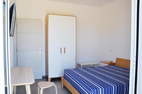 a bedroom with a blue and white bed and a chair at Splendida Villa NATURE-APPARTAMENTO MELOGRANO a SCOPELLO-ZINGARO vista sul mare in Scopello