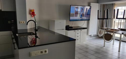 a kitchen with a counter and a tv on the wall at Osborne in Middelkerke