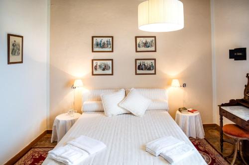 a bedroom with a white bed with two tables at Tenuta di Montemassi Fattoria in Montemassi