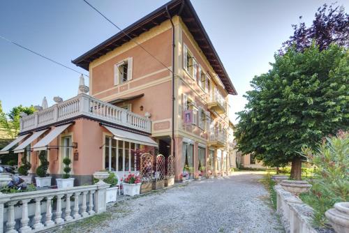 a house with a white fence next to a street at Duchessa Margherita Chateaux & Hotels in Vicoforte