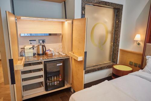 a hotel room with a bed and a kitchen in it at The Quorum in Lusaka