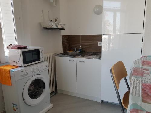 une cuisine avec un lave-linge et un micro-ondes dans l'établissement Studio with sea view for 2 people, à Toulon