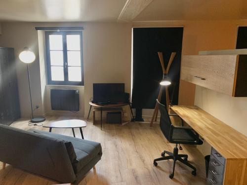 a living room with a couch and a desk at Les Cloutiers in Chalon-sur-Saône