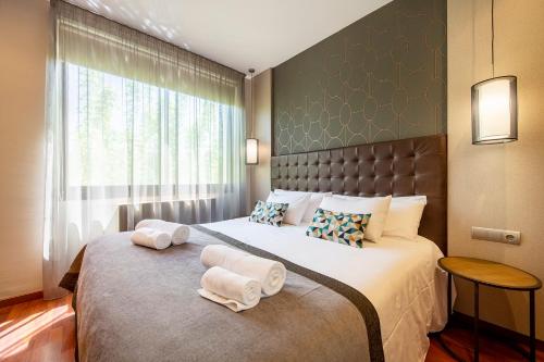 um quarto com uma cama grande e toalhas em UP ROOMS BANYOLES em Banyoles