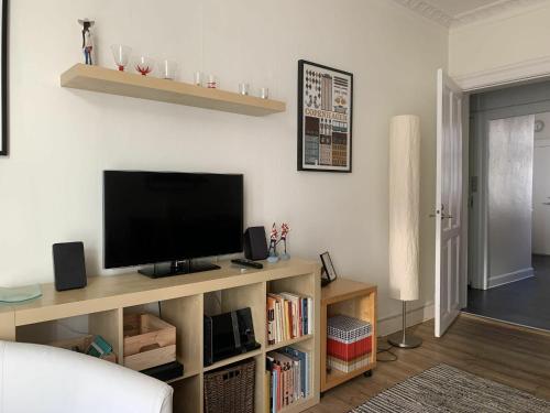 a living room with a flat screen tv on a book shelf at ApartmentInCopenhagen Apartment 510 in Copenhagen