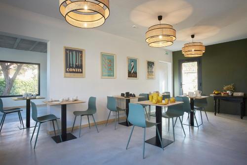 um restaurante com mesas e cadeiras num quarto em HOTEL COTE PHARE em Contis-les-Bains