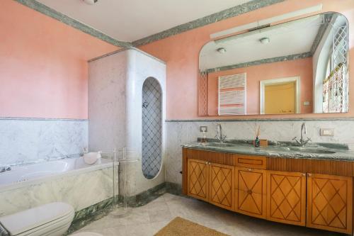 łazienka z wanną, umywalką i lustrem w obiekcie Luxury Garden House w mieście Pietrasanta