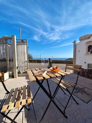a picnic table with a glass of wine on a patio at Il Riccio Apartment in Procida