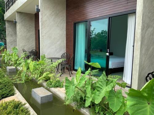 a garden with plants and a room with a bed at Saythong boutique hotel in Chiang Khan