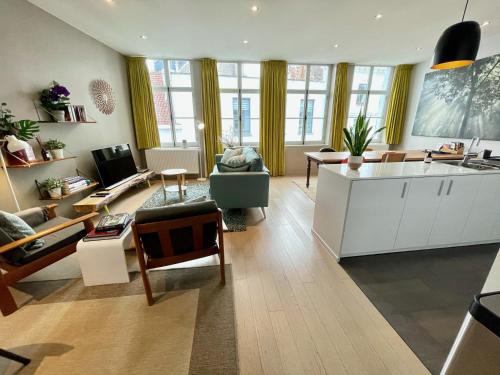 a living room with a kitchen and a living room with a couch at For Four Flat in Ghent