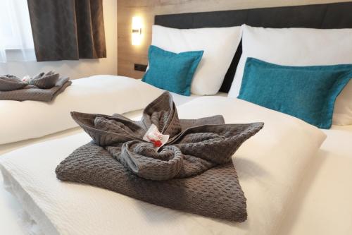 a hotel room with two beds with towels on them at Apart Alina in Schwendau