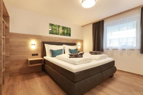 a bedroom with a large bed and a large window at Apart Alina in Schwendau