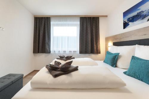 a hotel room with two beds and a window at Apart Alina in Schwendau