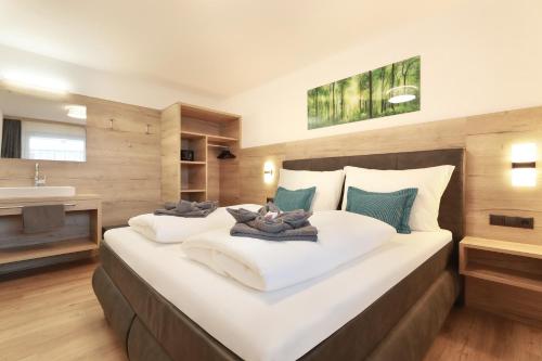 a bedroom with a large white bed with a sink at Apart Alina in Schwendau
