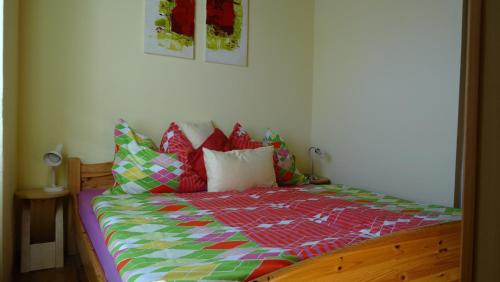 a bed with a colorful comforter and pillows on it at Haus Piber in Villach
