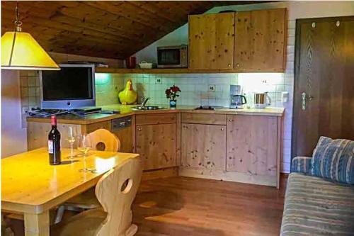 a kitchen with a table with a bottle of wine at Greobenlehen in Marktschellenberg