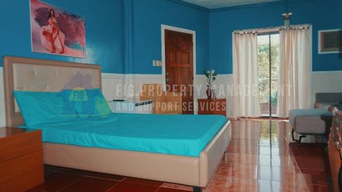 Un dormitorio con una cama y una pared azul. en Casita de Ruby Resort in Laguna, en Bay